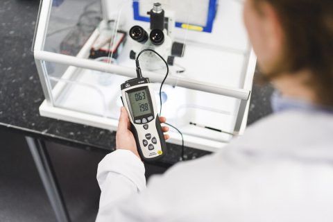 A close up of a hand holding a digital monitor A close up of a hand holding a digital monitor