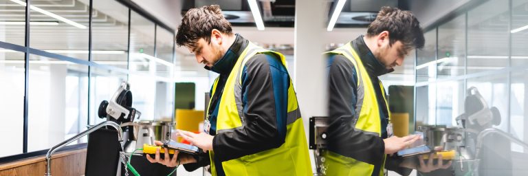 A man in a high vis jacket testing water with a gauge A man in a high vis jacket testing water with a gauge